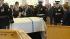 A military honor guard carries the casket of...