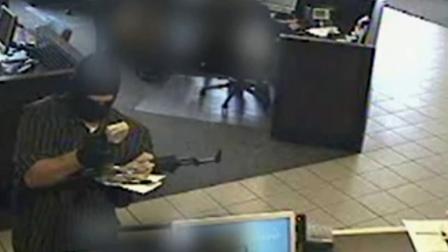 A bank robbery suspect dubbed the AK-47 Bandit is seen in this July 2012 surveillance video from a Washington bank.