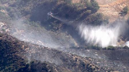 A water-dropping helicopter is seen containing a fire in Banning Monday, Sept. 17, 2012.