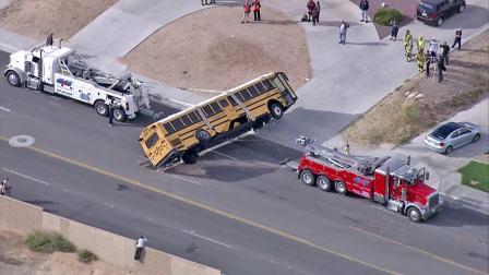 Two big-rig tows are seen picking up a school bus after it crashed into a U-Haul truck while transporting 40 students from Galileo Academy in Victorville on Thursday, Oct. 11, 2012. The cause of the crash was not immediately known.
