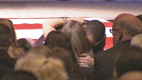 Wife Regina Crain hugs a friend during a funeral service at Grove Community Church in Riverside for Officer Michael Crain on Wednesday, Feb. 13, 2013.