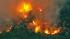 A brush fire is seen in a riverbed in Jurupa...