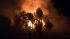 A brush fire is seen in a riverbed in Jurupa...