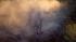 A brush fire is seen in a riverbed in Jurupa...