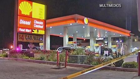 Police are seen at a gas station in Colton where a corrections officer was shot Thursday, May 2, 2013. The officers condition is unknown.