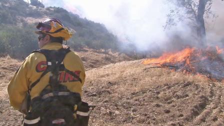 A firefighter works to put out the Summit Fire in Banning in this April 2013 photo.