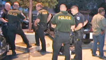 San Bernardino police officers gather at the scene, where two undercover officers were fired upon while they were traveling in their unmarked vehicle near the 2500 block of West Foothill Boulevard on Tuesday, Aug. 27, 2013.
