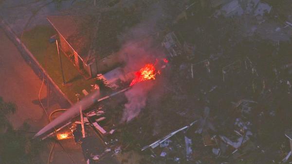 An explosion leveled a home and set at least two others on fire Friday in Riverside. Firefighters are shown spraying down flames spouting from a natural gas line at the scene of the blast on Friday, Sept. 6, 2013.