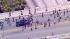 Skateboarders hang on to a pickup truck on an...