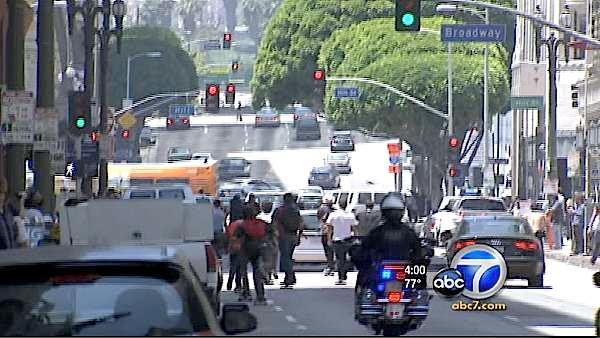 An LAPD motorcycle officer trails skateboarders riding in the streets of downtown Los Angeles during the 'Wild in the Streets' event in celebration of 'Go Skateboarding Day' on Tuesday, June 21, 2011.