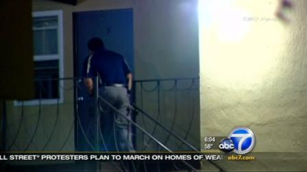 Authorities investigate a home where a man and woman were found dead on Monday, Oct. 10, 2011.