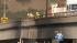 Crews inspect a scorched overpass after a...