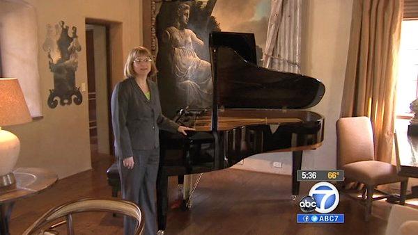 Donna Gotch, Benefit Chair for Pasadena Showcase House for the Arts, stands next to a piano.