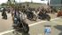 Motorcycle riders head down the parade route of...