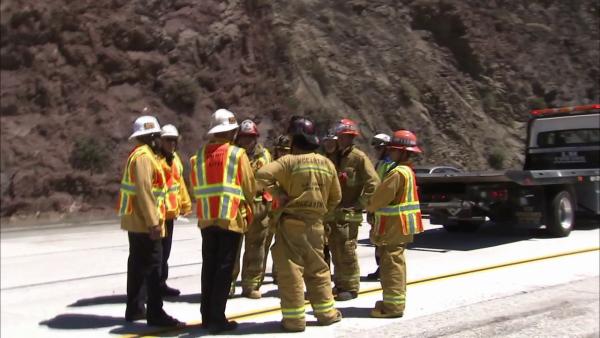 Los Angeles County Fire officials are seen next to a 19-vehicle accident on the southbound 14 Freeway in Agua Dulce on Tuesday, June 26, 2012.