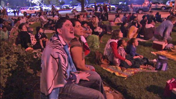 A man is seen smiling at the fireworks in the sky outside the Rose Bowl at Pasadena's annual Americafest on Wednesday, July 4, 2012.