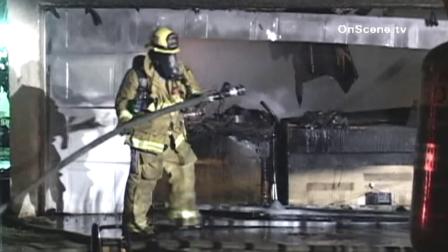 A firefighter battles a blaze at a Compton garage. Authorities say the fire was sparked by illegal fireworks.