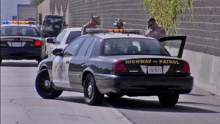 CHP officers are seen at the site of an officer-involved shooting that shut down the westbound 60 Freeway at Hacienda Boulevard on Saturday, August 4, 2012.