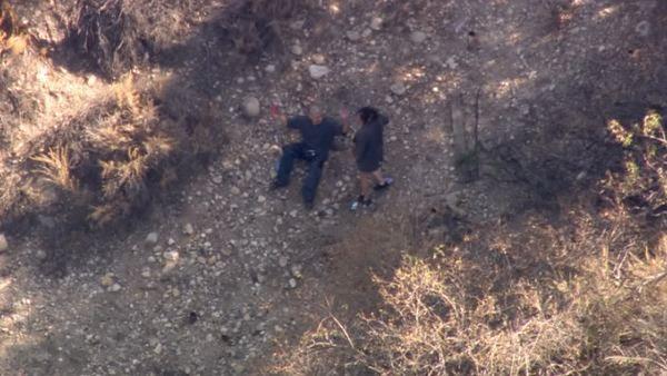 A male DUI suspect and his female passenger are seen resting on a hillside as they try to dodge police after a pursuit on Friday, August 31, 2012.