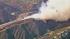 A brush fire is seen burning near homes in the...