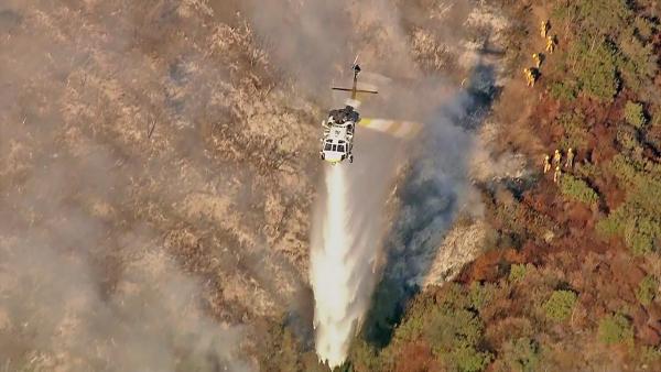 A helicopter is seen fighting a fire that burned in the Sepulveda Pass near the 405 Freeway at Getty Center drive on Friday, September 14, 2012.