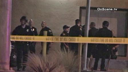 Police are shown behind crime scene tape near a Long Beach apartment complex, where gunshots were reported on Friday, Sept. 14, 2012.