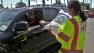 A Southern California Edison worker hands out a bag of ice to a customer during a power outage that lasted nearly 24 hours during a summer heat wave on Sunday, Sept. 16, 2012.