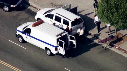 Los Angeles coroners arrive at the scene on Main Street in South L.A. after a womans body was found in the backseat of an SUV on Thursday, Sept. 27, 2012.