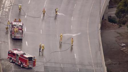 Crews hose down northbound lanes of the 101 Freeway after a lime spill created a mess on the roadway on Thursday, Oct. 18, 2012.