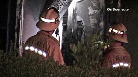 Firefighters survey the damage after a fire burned through a home in the 900 block of East 222nd Street in Carson on Saturday, Oct. 27, 2012.