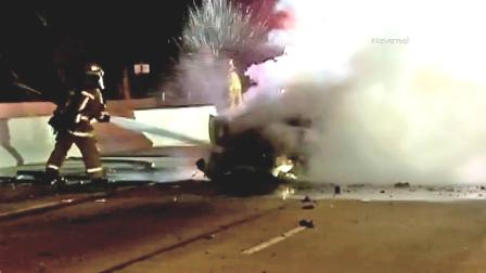 A firefighter hoses down car after it caught fire following a crash on the 405 Freeway in Sherman Oaks on Sunday, Nov. 11, 2012.