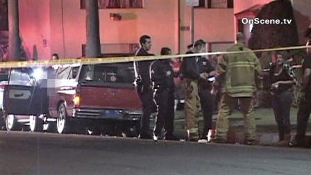 Law enforcement and fire officials gather behind police tape near the scene of a fatal shooting on North Marine Avenue in Wilmington on Thursday, Nov. 15, 2012.