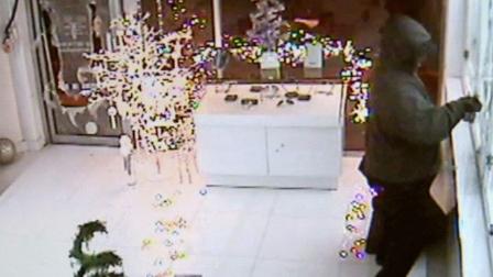 A suspect is shown smashing glass to steal sunglasses from Blue Eyes Optometry in Glendale, Calif.