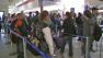 Travelers stand in line at the airport in this undated file photo.