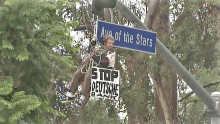 A protester dangles from an overhead traffic light on Avenue of the Stars in Century City on Thursday, Nov. 29, 2012.