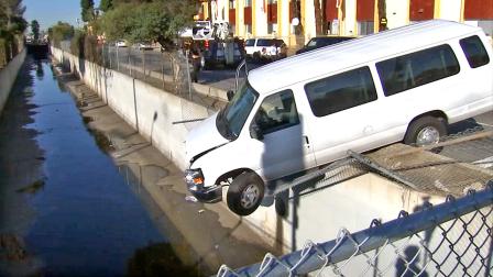 A van carrying a youth group crashed through a fence and dangled from the wall of a wash in North Hills on Saturday, Dec. 8, 2012.