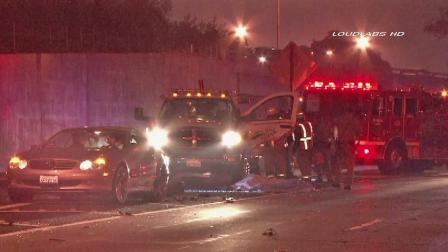 Firefighters are shown at the scene of a crash where a tow truck driver was struck by a passing car and killed in Signal Hill on Sunday, Dec. 9, 2012.