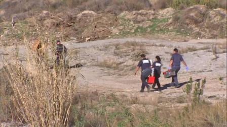 Investigators are seen near Big Tujunga Canyon Road where human remains were found on Saturday, Jan. 19, 2013.