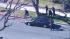 Police officers cautiously approach a vehicle at...