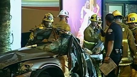 Firefighters are seen at the scene of a crash on Van Nuys Boulevard in Van Nuys that killed a female passenger and hospitalized the driver on Saturday, Feb. 16, 2013. Officials said alcohol and high speeds are to blame.