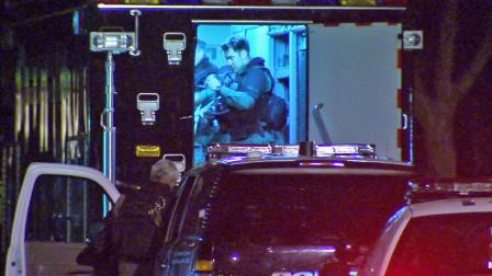 Law enforcement officers are shown near the scene of a hostage situation in the 2900 block of Delaware Avenue in Santa Monica.