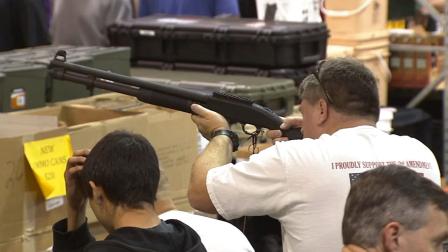 A man looks down the sight of a shotgun at the Glendale Gun Show on Saturday, March 2, 2013.