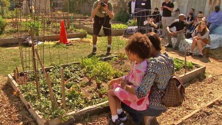 Residents enjoy a new community garden made possible by local philanthropist Erika Glazer, who donated $150,000 to rejuvenate a vacant lot in South Los Angeles.