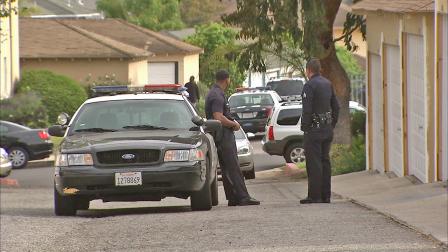 Police officers are seen at an apartment building in the Crenshaw District of Los Angeles, where a man was found shot to death on Sunday, April 7, 2013.