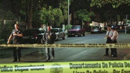 Los Angeles investigators are shown behind crime scene tape following an officer-involved shooting in Lake View Terrace on Friday, May 17, 2013.