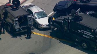 Armored police vehicles surround a vehicle at the end of a brief chase in the South Los Angeles area on Monday, June 17, 2013. The driver refused to come out of the vehicle.