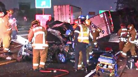 Emergency officials are shown at the scene of a crash involving a big rig and a stalled car on the southbound 405 Freeway in Hawthorne on Friday, June 28, 2013.