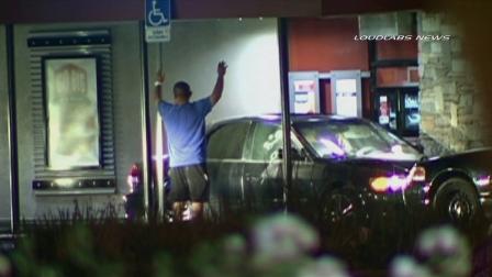 A man is seen with his hands in the air after a standoff in the drive-thru of the Jack in the Box at Telegraph and Carmenita roads in Santa Fe Springs on Thursday, July 4, 2013.