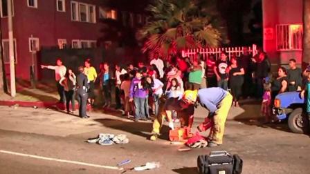 Emergency officials are shown at the scene of a fatal hit-and-run crash at the intersection of Avalon and 84th Street in South Los Angeles on Thursday, July 4, 2013.