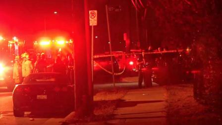 Emergency officials are shown at the scene of a fatal shooting at a party near Hoover Street and El Segundo Boulevard in South Los Angeles on Saturday, July 6, 2013.